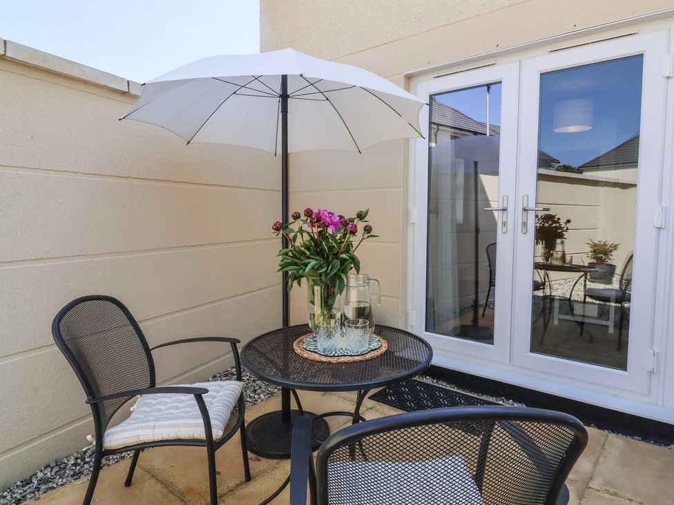 An outdoor seating area with a table and chairs at Seashell Sands in Appledore