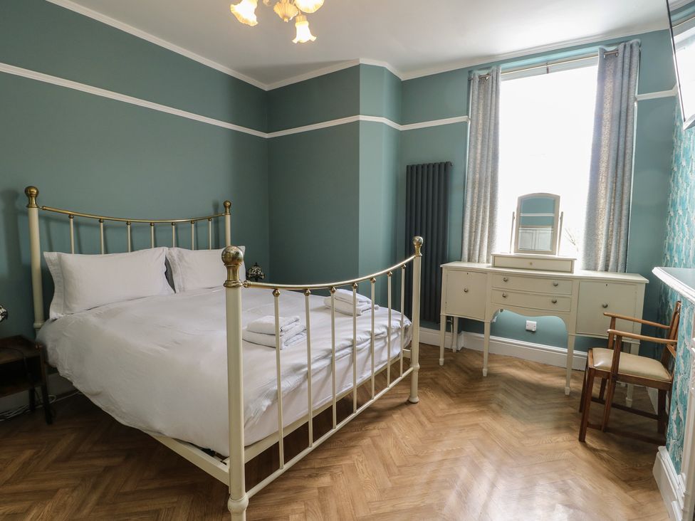 A bedroom with a bed and a dressing table at Noah's Rest in Llandudno