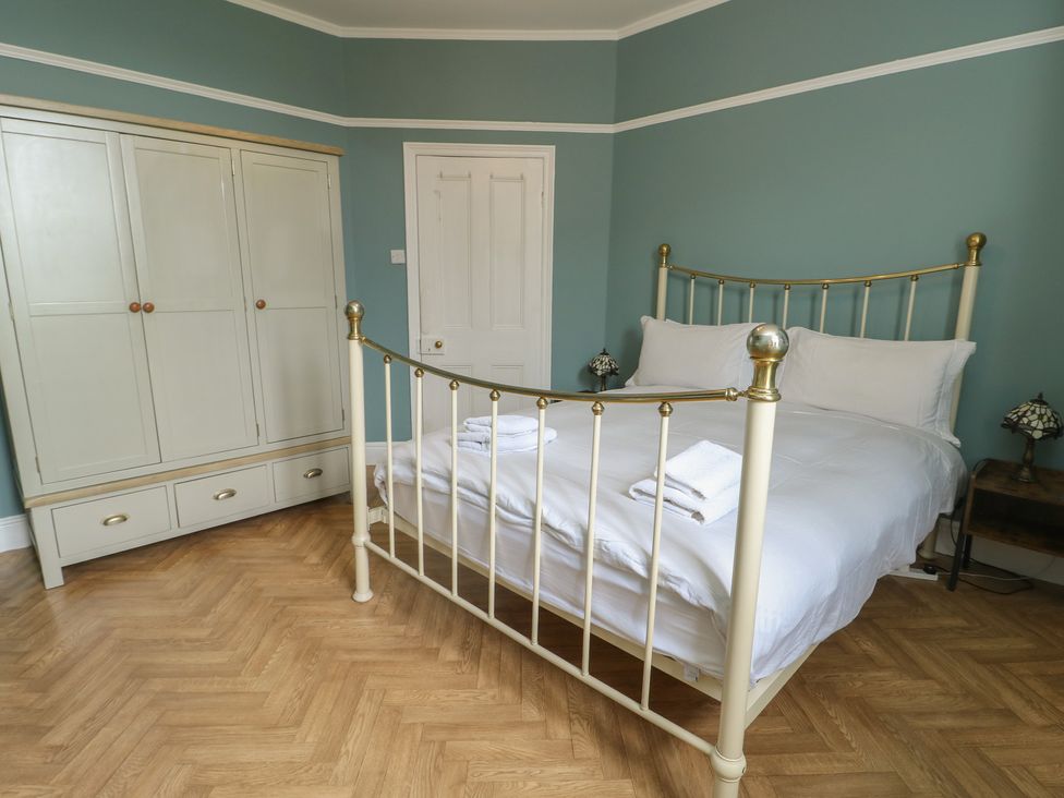 A bedroom with a bed and wardrobe at Noah's Rest in Llandudno