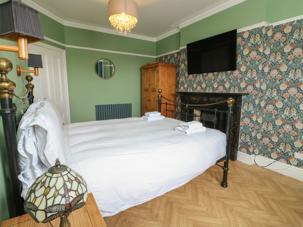A bedroom with a bed and wardrobe at Noah's Rest in Llandudno