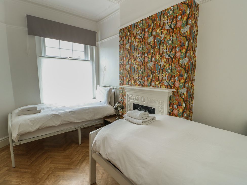 A bedroom with two beds and a window at Noah's Rest in Llandudno