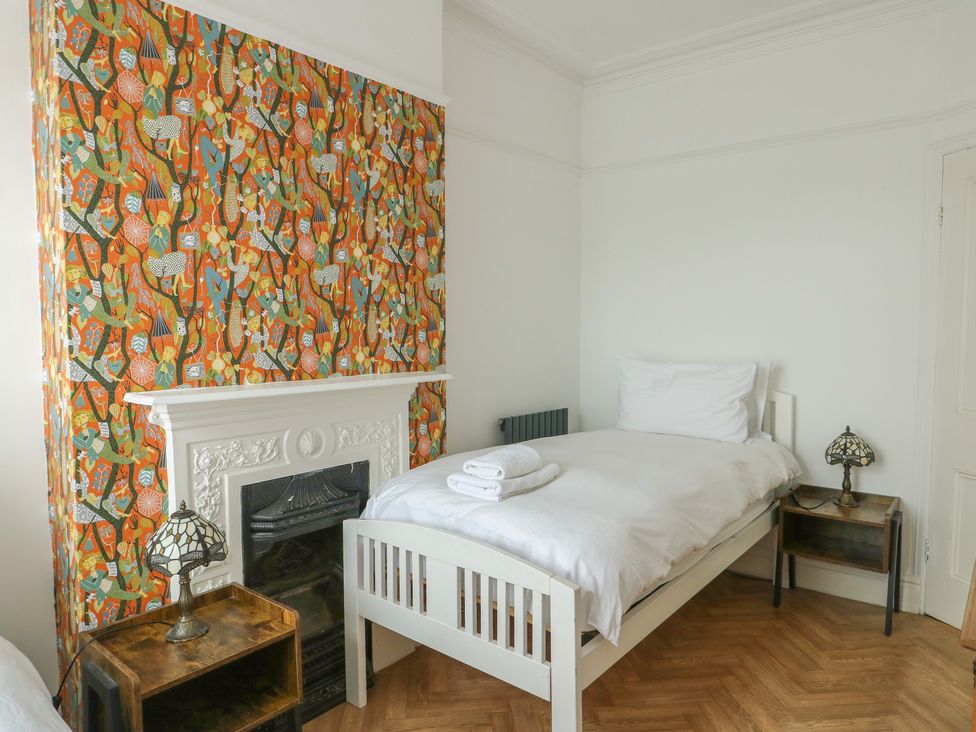 A bedroom with a single bed and a fireplace at Noah's Rest in Llandudno