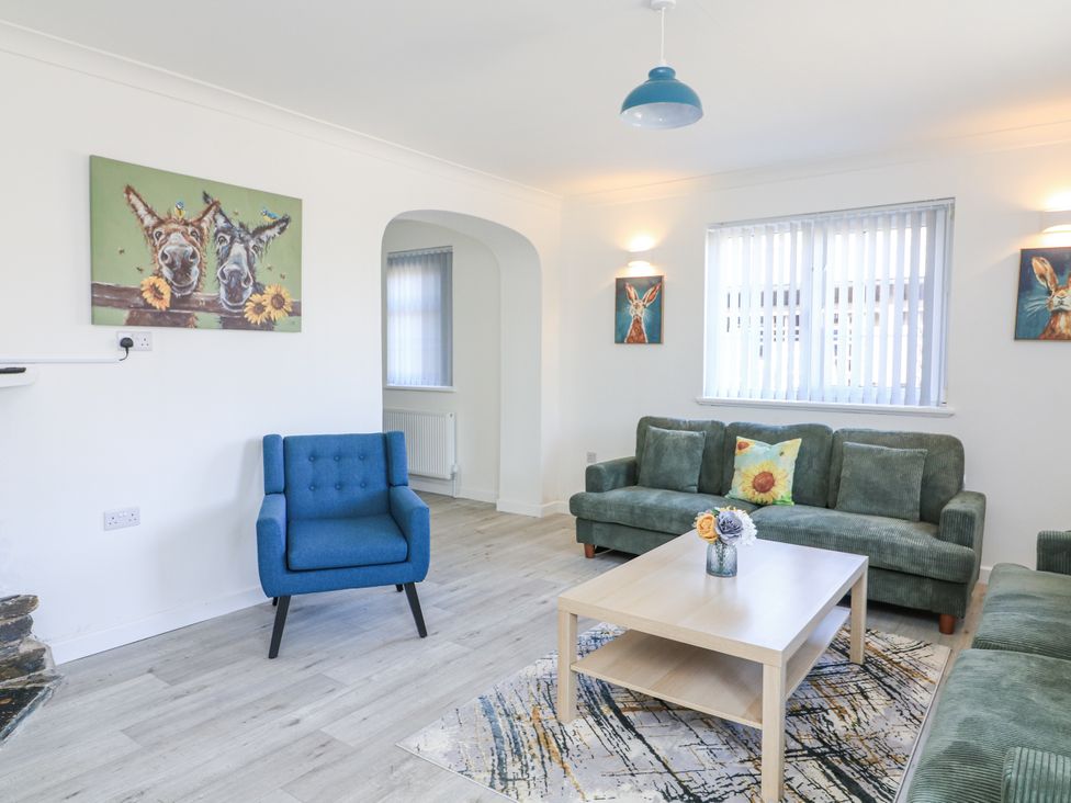A living room with a sofa and armchair at Hougoumont Cottage in Torpoint