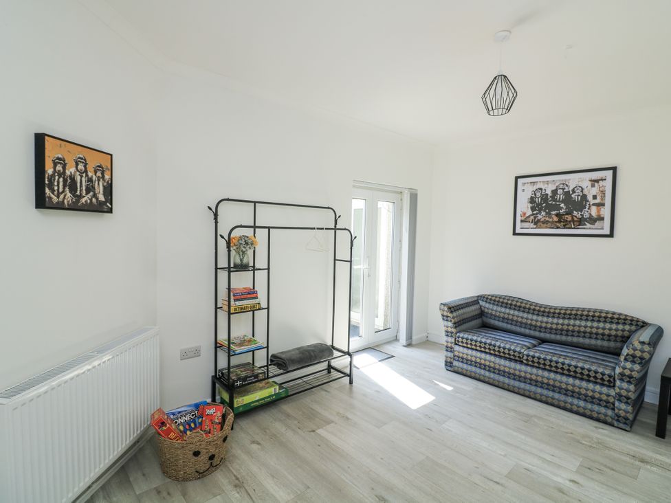 A living room with a sofa and shelf at Hougoumont Cottage in Torpoint