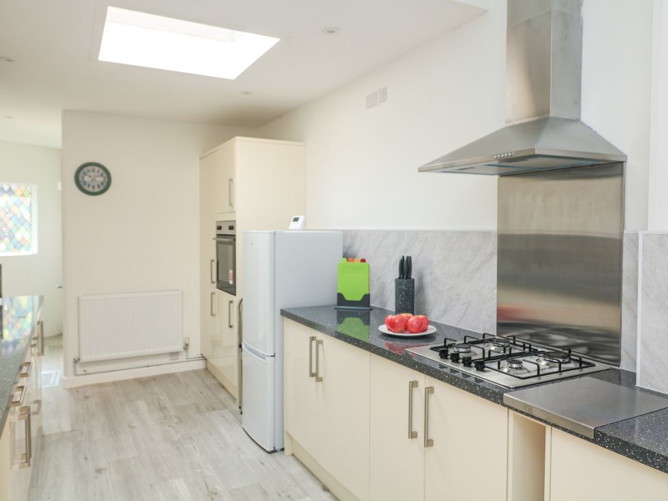 A kitchen with a stove and refrigerator at Hougoumont Cottage in Torpoint