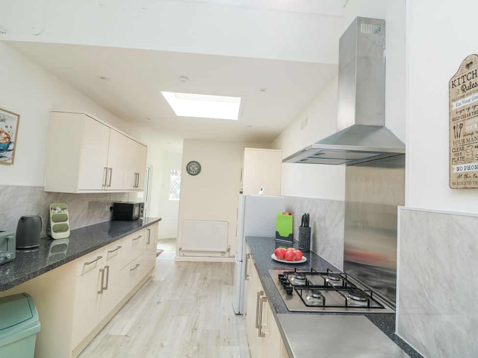 A kitchen with a countertop, stove, and various appliances at Hougoumont Cottage in Torpoint