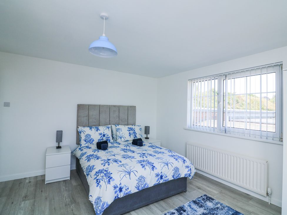 A bedroom with a bed and bedside tables at Hougoumont Cottage in Torpoint