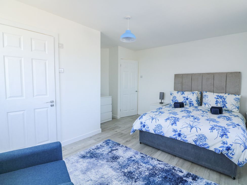 A bedroom with a bed and nightstand at Hougoumont Cottage in Torpoint
