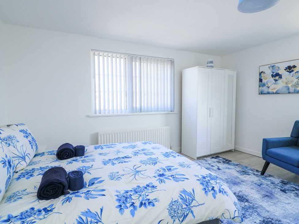 A bedroom with bed and wardrobe at Hougoumont Cottage in Torpoint