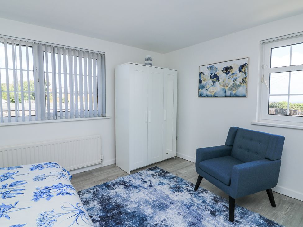 A bedroom with a bed and wardrobe at Hougoumont Cottage in Torpoint