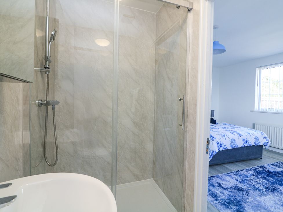 A bathroom with a shower and a view of the bedroom at Hougoumont Cottage Torpoint