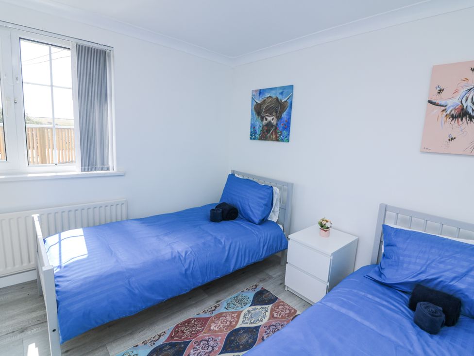 A bedroom with two beds and a window at Hougoumont Cottage Torpoint