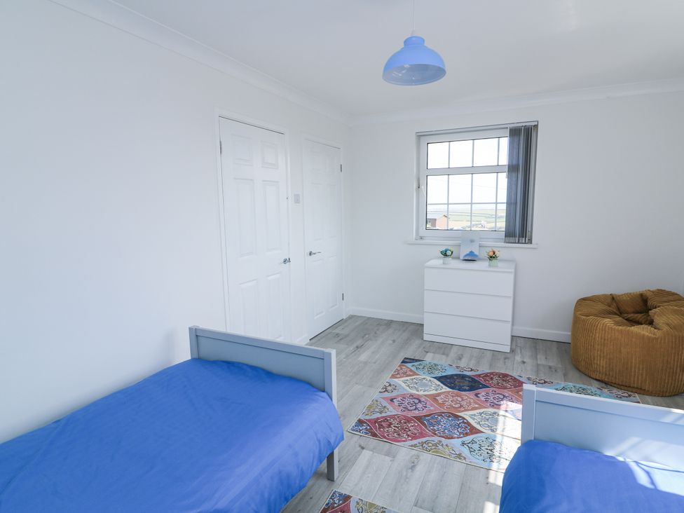 A bedroom with two beds and a dresser at Hougoumont Cottage in Torpoint