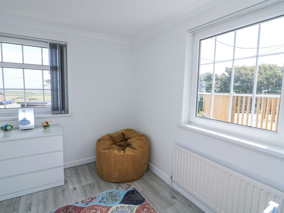 A bedroom with a bean bag and a window at Hougoumont Cottage in Torpoint