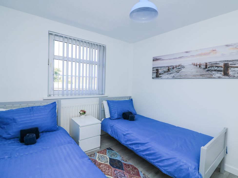 A bedroom with two beds and a nightstand at Hougoumont Cottage in Torpoint