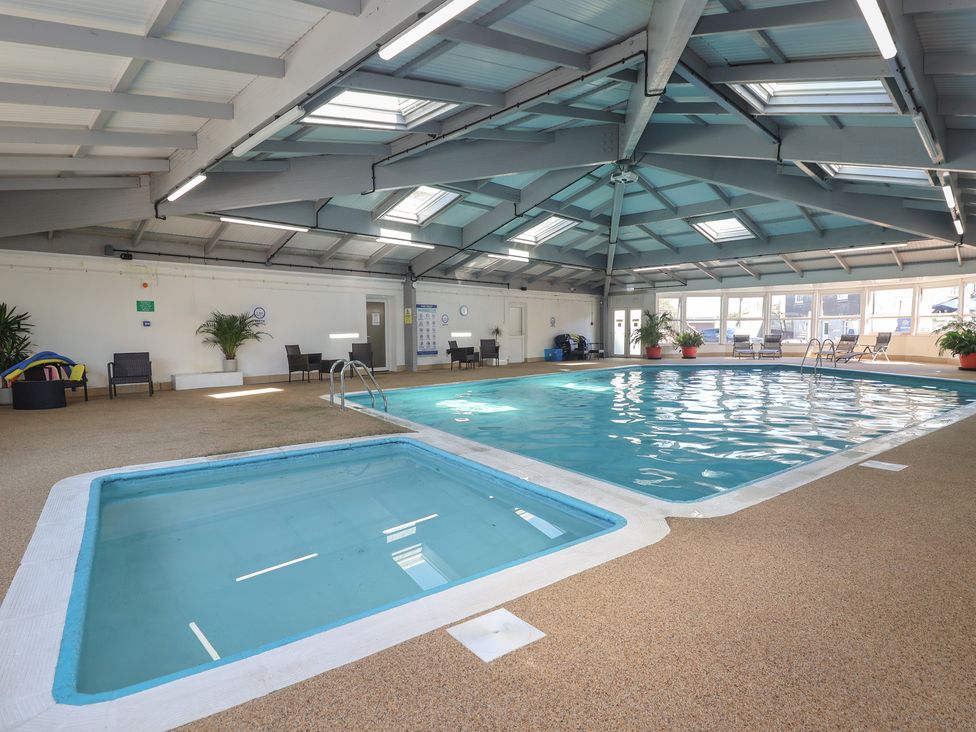 An indoor pool area with a jacuzzi and seating at Hougoumont Cottage in Millbrook