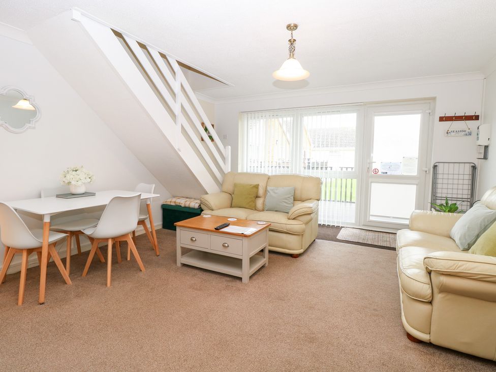 A living room with a staircase and seating area at 19 Waterside Park in Corton