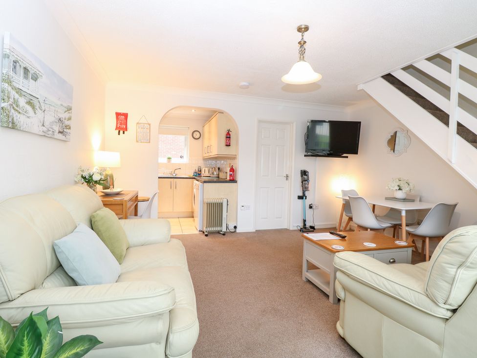 A living room with a sofa and a television at 19 Waterside Park in Corton