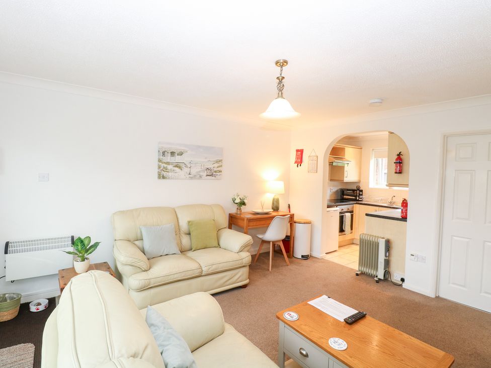 A living room with a sofa and desk at 19 Waterside Park in Corton