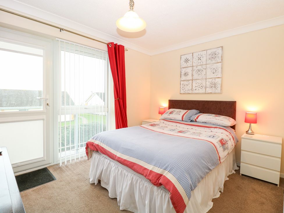 A bedroom with a bed and bedside tables at 19 Waterside Park in Corton
