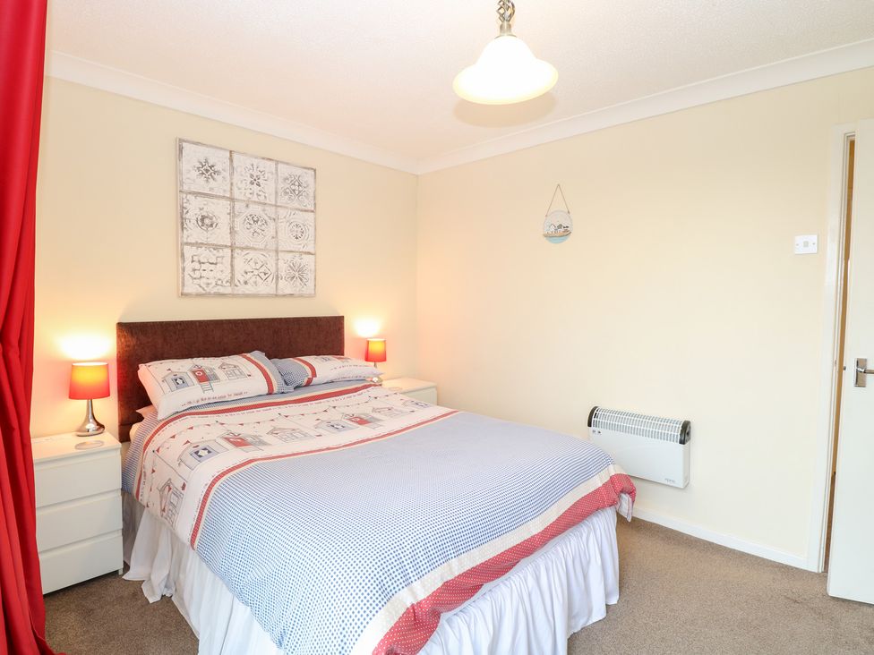 A bedroom with a bed and bedside lamps at 19 Waterside Park in Corton