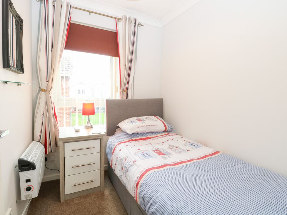 A bedroom with a single bed and nightstand at 19 Waterside Park in Corton
