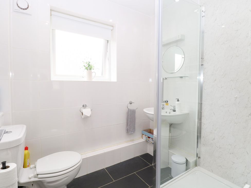 A bathroom with a shower, toilet, and sink at 19 Waterside Park in Corton