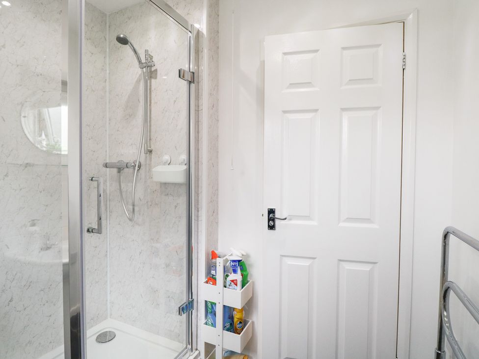 A bathroom with a glass shower enclosure at 19 Waterside Park in Corton