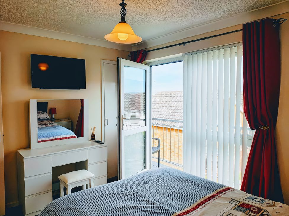 A bedroom with a bed and a mirror at 19 Waterside Park Corton