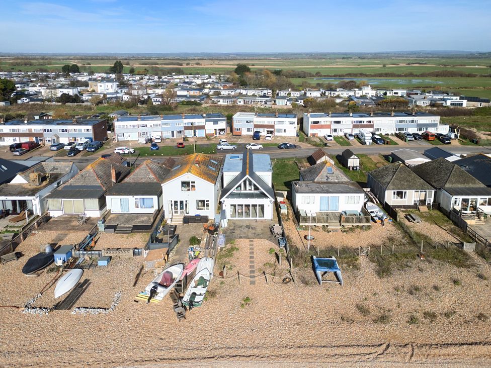 A beachfront view of houses and boats at Bucket and Spades- Right on the Beach Pevensey Bay