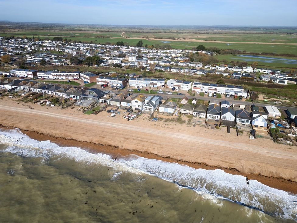 A beachfront area with houses and water at Bucket and Spades- Right on the Beach Pevensey Bay