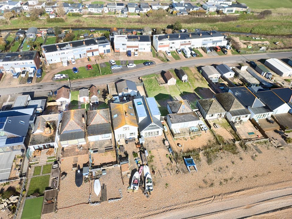 An aerial view of houses and boats near the beach at Bucket and Spades- Right on the Beach Pevensey Bay