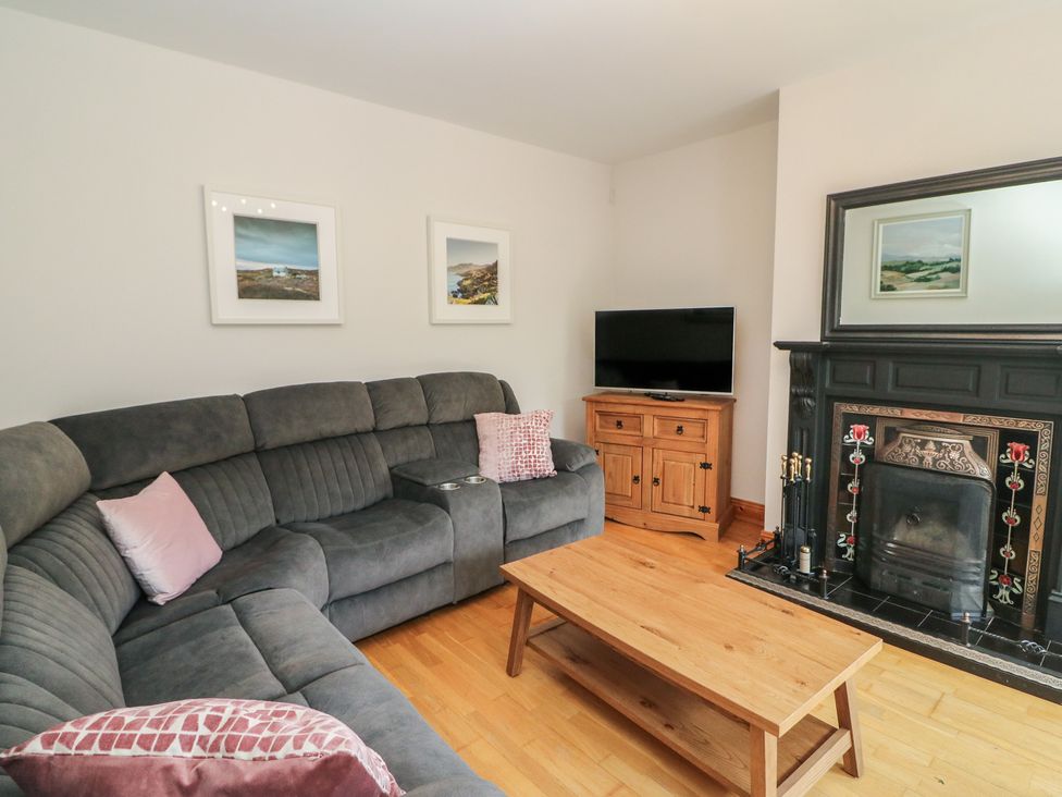 A living room with a sofa, coffee table, and television at The Skating Rock in Bunane near Kenmare, County Kerry