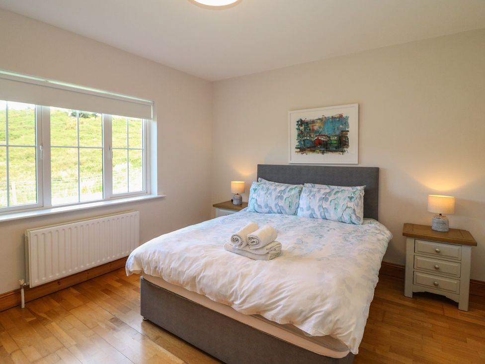 A bedroom with a bed and bedside tables at The Skating Rock in Bunane near Kenmare, County Kerry