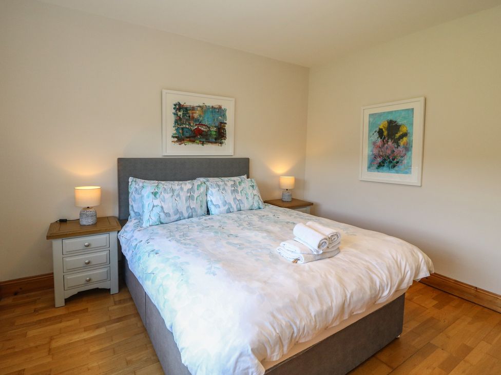 A bedroom with a bed and bedside table at The Skating Rock in Bunane near Kenmare, County Kerry