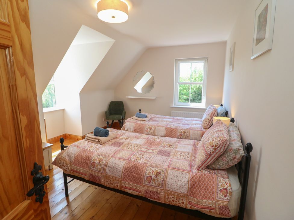 A bedroom with two beds and a window at The Skating Rock in Bunane near Kenmare, County Kerry