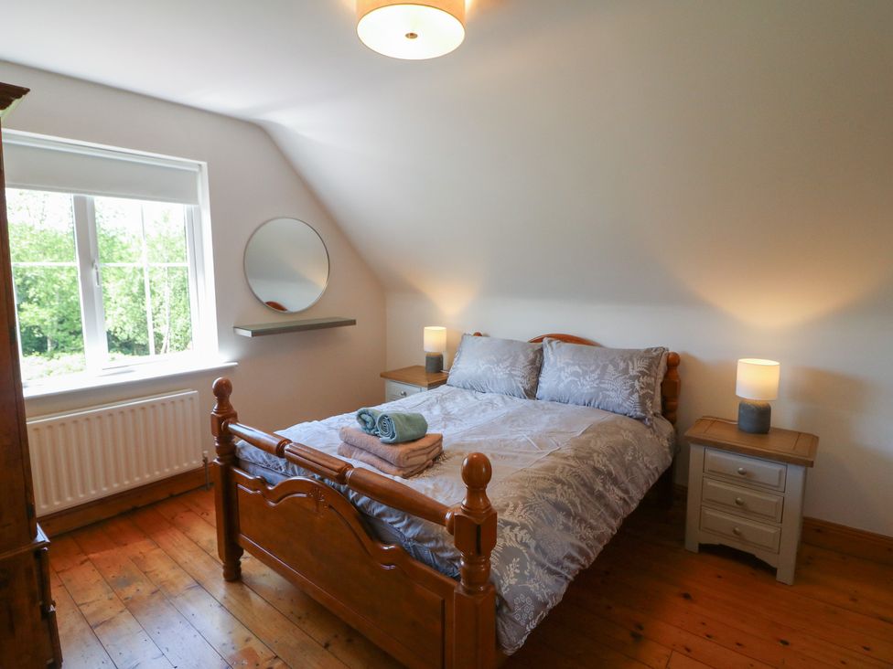 A bedroom with a bed and two bedside tables at The Skating Rock in Bunane near Kenmare, County Kerry