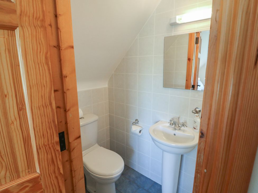 A bathroom with toilet, sink, and mirror at The Skating Rock in Bunane near Kenmare, County Kerry