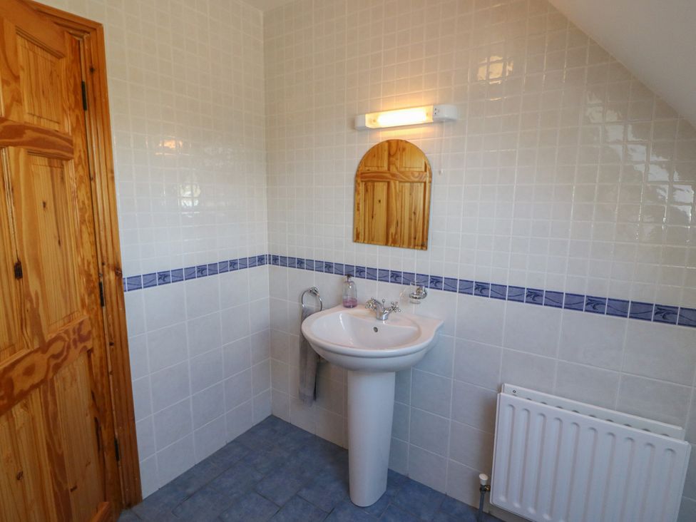 A bathroom with a sink and mirror at The Skating Rock in Bunane near Kenmare, County Kerry