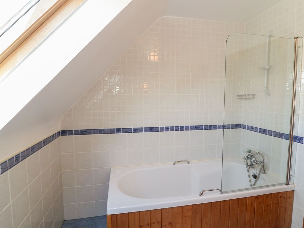 A bathroom with a bathtub and shower at The Skating Rock in Bunane near Kenmare, County Kerry