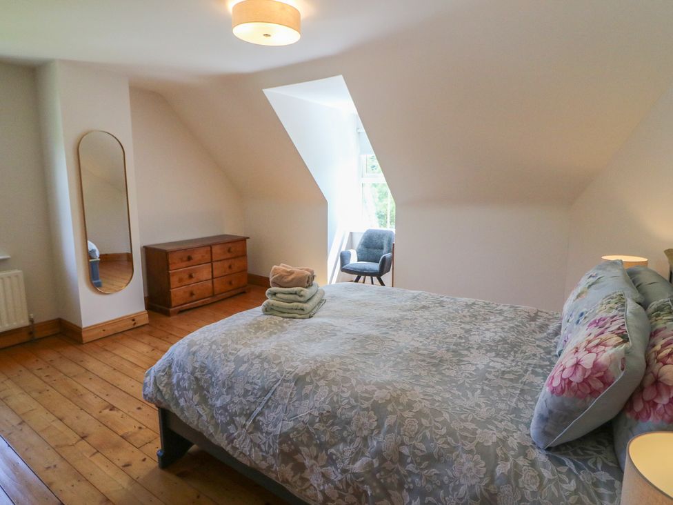 A bedroom with a bed and dresser at The Skating Rock in Bunane near Kenmare, County Kerry