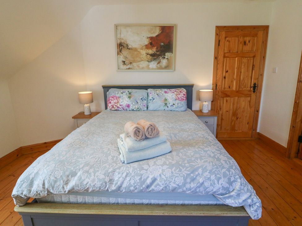 A bedroom with a bed and bedside table at The Skating Rock in Bunane near Kenmare, County Kerry