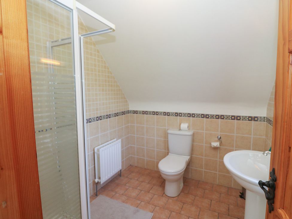 A bathroom with a shower, toilet, and sink at The Skating Rock in Bunane near Kenmare, County Kerry