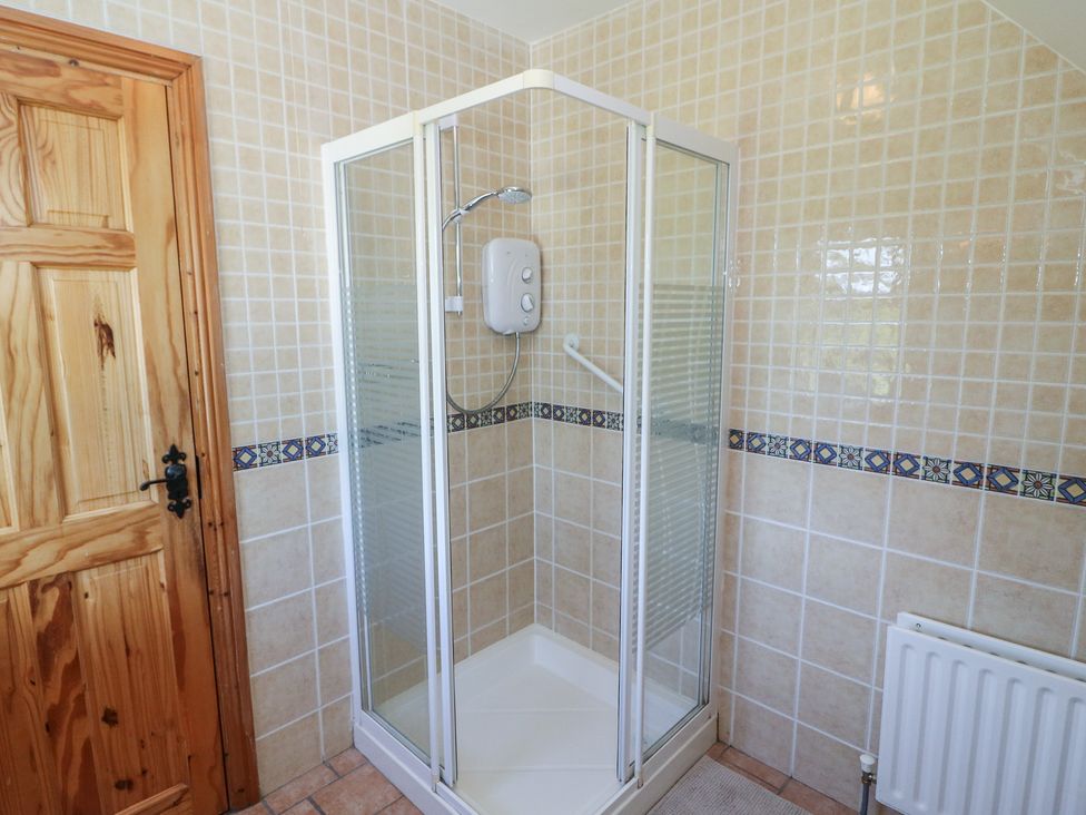 A shower enclosure with tiles and a radiator at The Skating Rock in Bunane near Kenmare, County Kerry