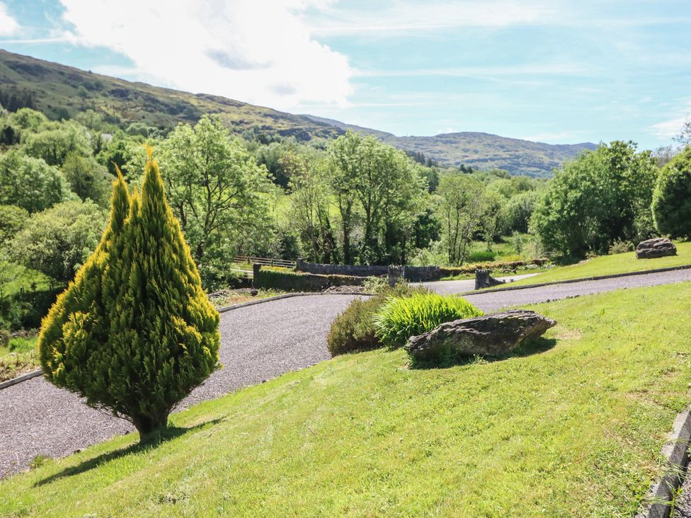 A view of a garden with trees and a gravel path at The Skating Rock in Bunane near Kenmare, County Kerry