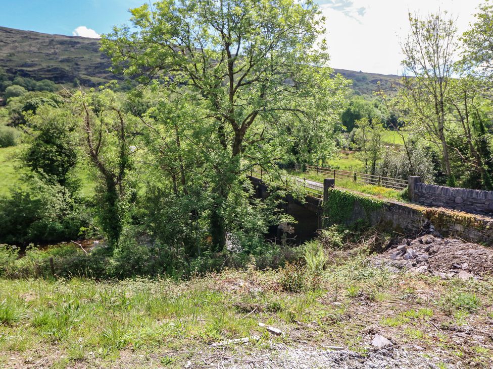 A scenic view with trees and a bridge at The Skating Rock in Bunane near Kenmare, County Kerry