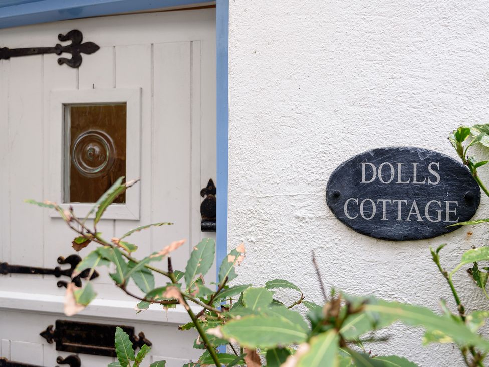 The entrance area with a door and sign at Dolls Cottage in Looe