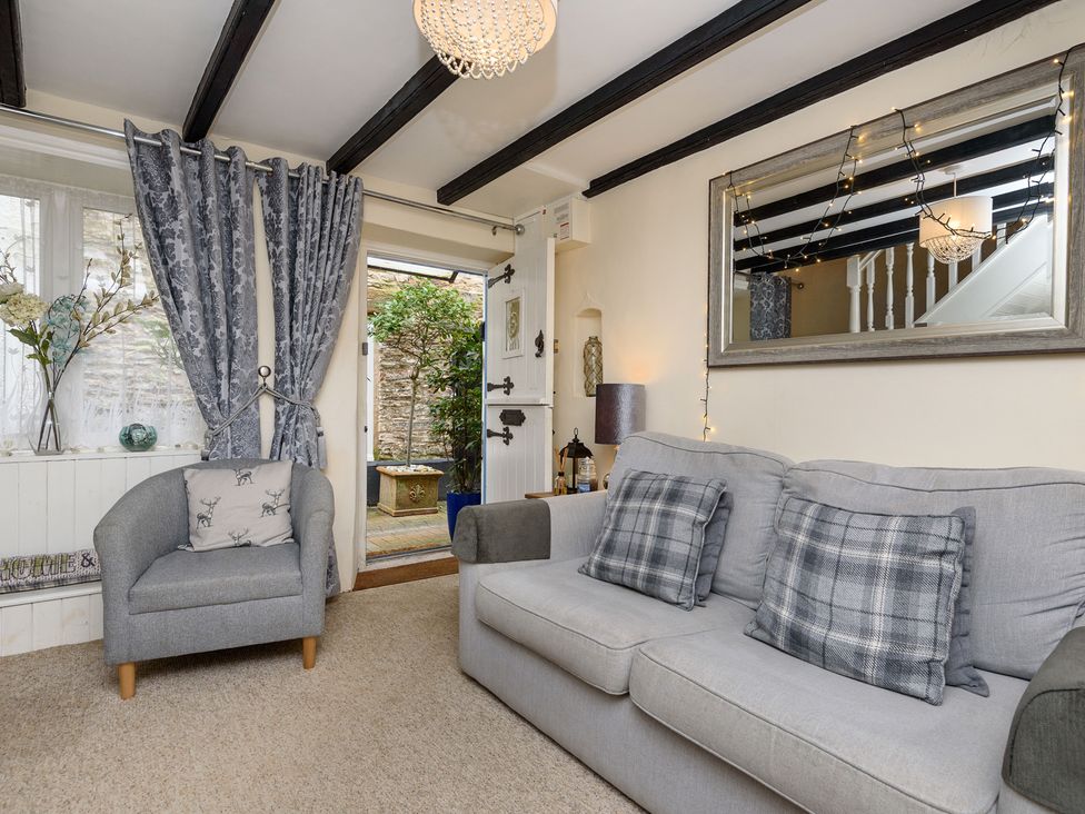 A living room with a sofa and an armchair at Dolls Cottage in Looe