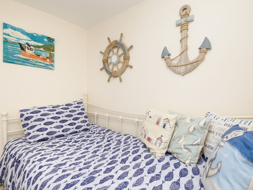 A bedroom with bed and nautical decor at Dolls Cottage in Looe