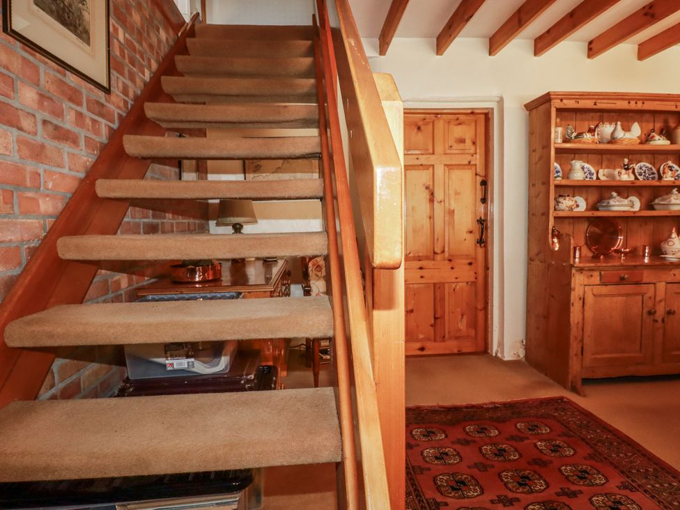 A staircase and wooden door in a hallway at Temple House in Goonhavern